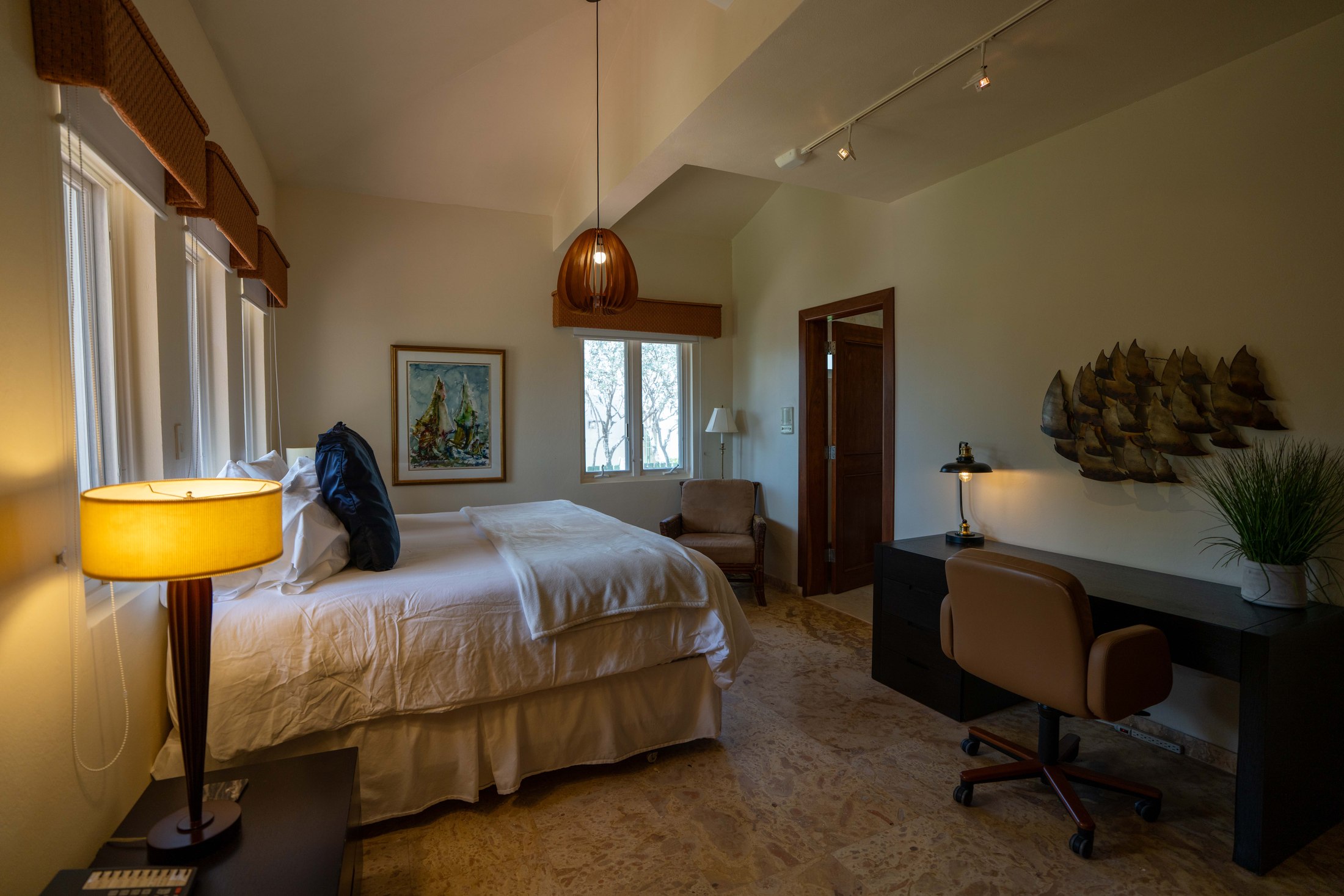 Guest bedroom with vaulted ceiling, king bed and desk